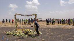A mourner lays flowers at the Memorial Arch during a visit to the crash site of Ethiopian Airlines Flight ET302 on March 14, 2019 in Ejere, Ethiopia. All 157 passengers and crew perished after the Ethiopian Airlines Boeing 737 Max 8 Flight came down six minutes after taking off from Bole Airport.