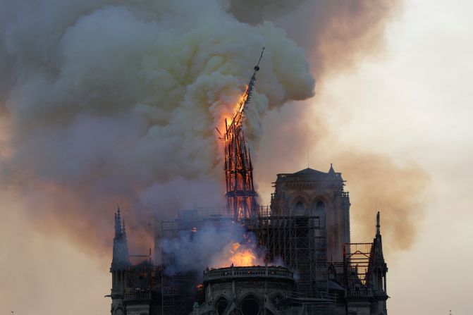 The steeple and spire collapse as the roof of the Notre Dame burns.