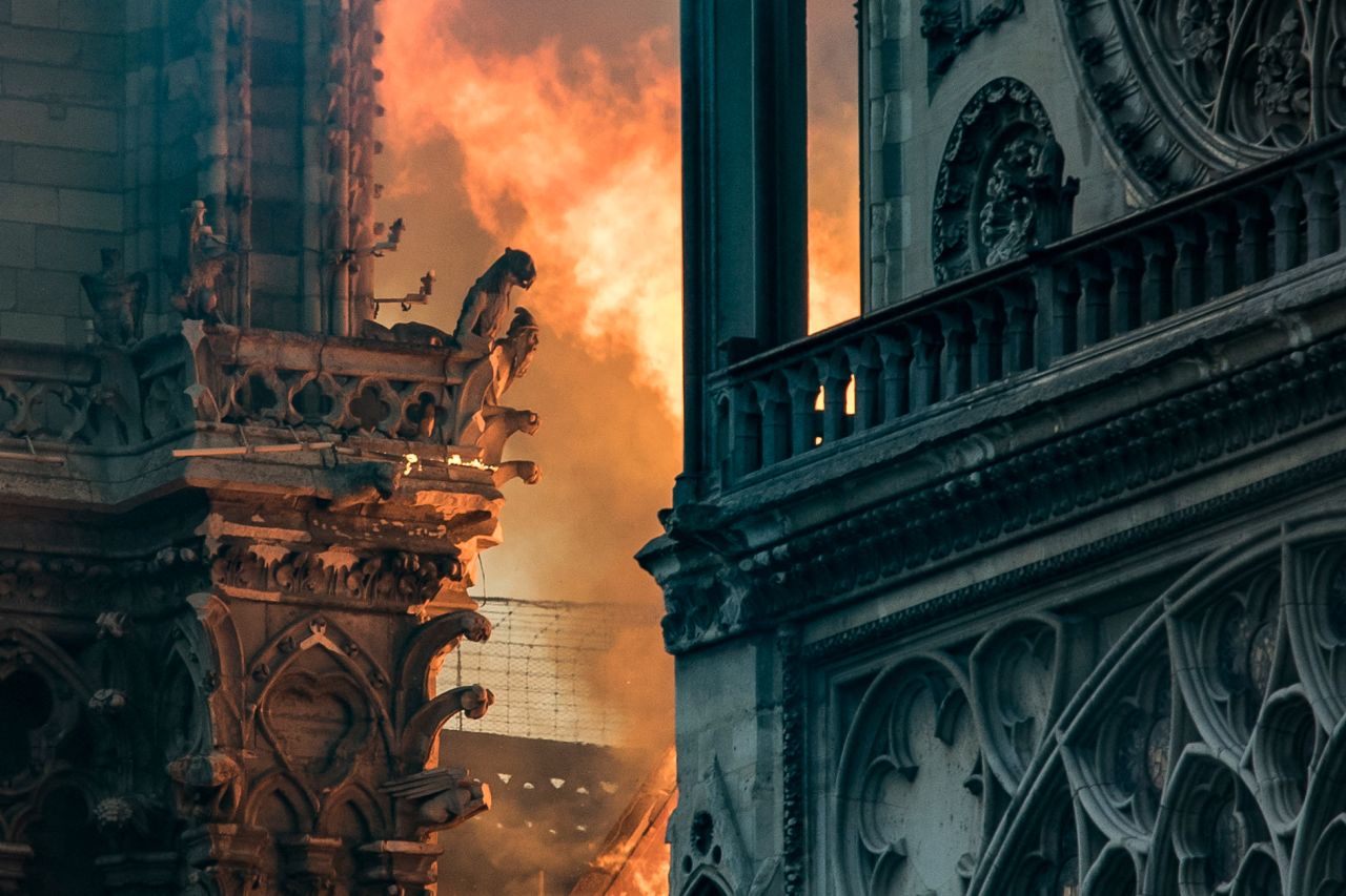 Flames and smoke billow around the gargoyles decorating the roof and sides of Notre Dame.