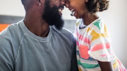 father and daughter laughing in bedroom