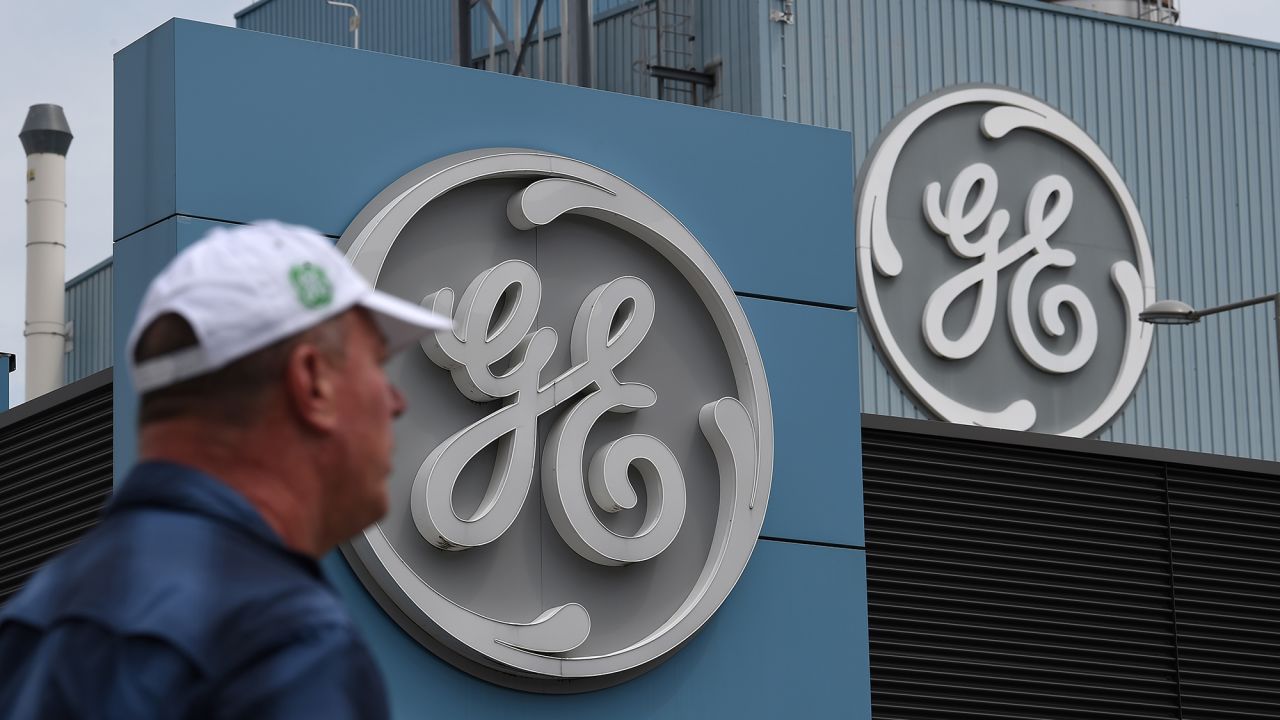 A General Electric employee walks past a logo, as French Economy and Finance Minister Bruno Le Maire take part to a meeting with managers and unions at the GE headquarter in Belfort, eastern France, on June 3, 2019. - General Electric has announced on May 28, 2019, his desire to eliminate more than 1,000 positions in France, including 792 in the Belfort entity that produces gas turbines and 252 in other entities dedicated to "support functions.
