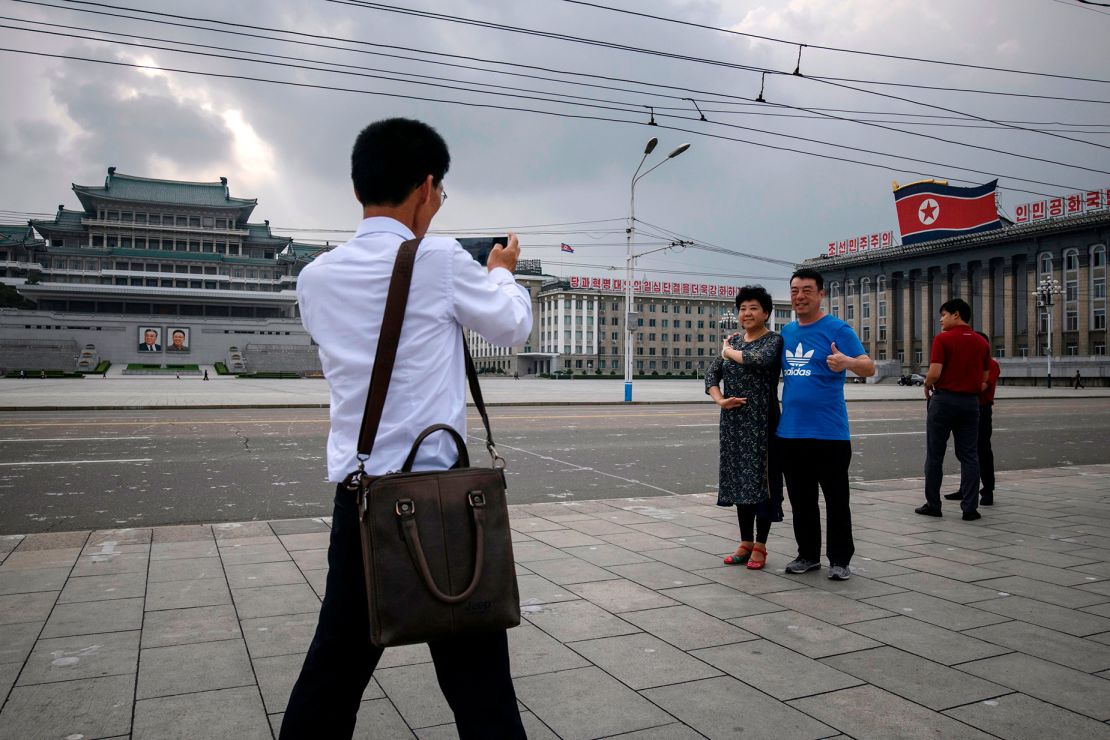 Chinese tourists pose for photos on Kim Il Sung Square in 2019.