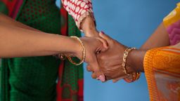 Indian women holding hands.