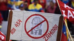 CARACAS, VENEZUELA - AUGUST 10: A pro-government supporter holds a banner with the image of Donald Trump, United State's president during a speech in an anti-trump demostration on August 10, 2019 in Caracas, Venezuela. President Nicolas Maduro called a demonstration against Donal Trump after US president imposed an economic embargo to Venezuela barred transactions with its authorities. This also generated the freeze on the negotiations with opposition leader Juan Guaidó in Barbados. (Photo by Carolina Cabral/Getty Images)