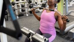 Mature woman weight training in gym