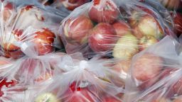 La France. Seine et Marne. Summer country party. Close-up on apples "Gala" in plastic bags ready for sale.