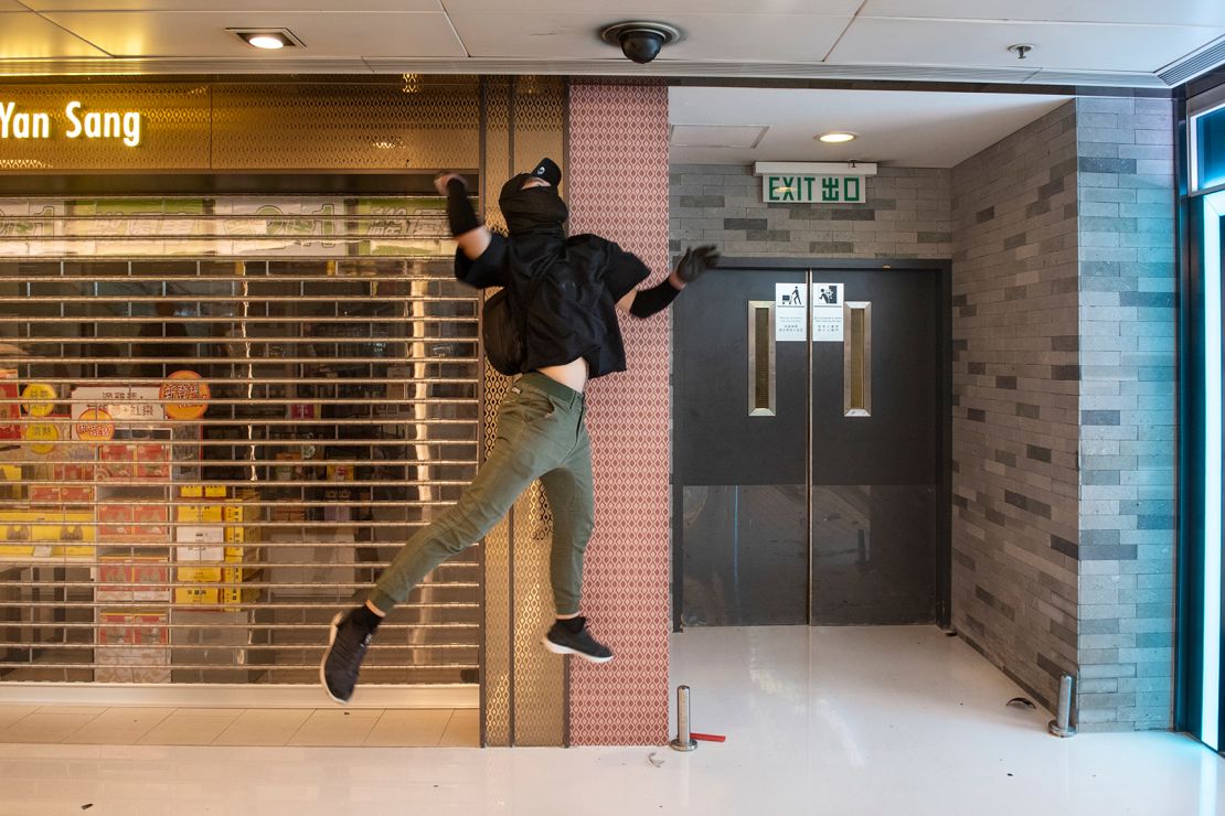 A protester jumps to smash a security camera at the New Town Plaza shopping mall in Hong Kong on October 13, 2019.