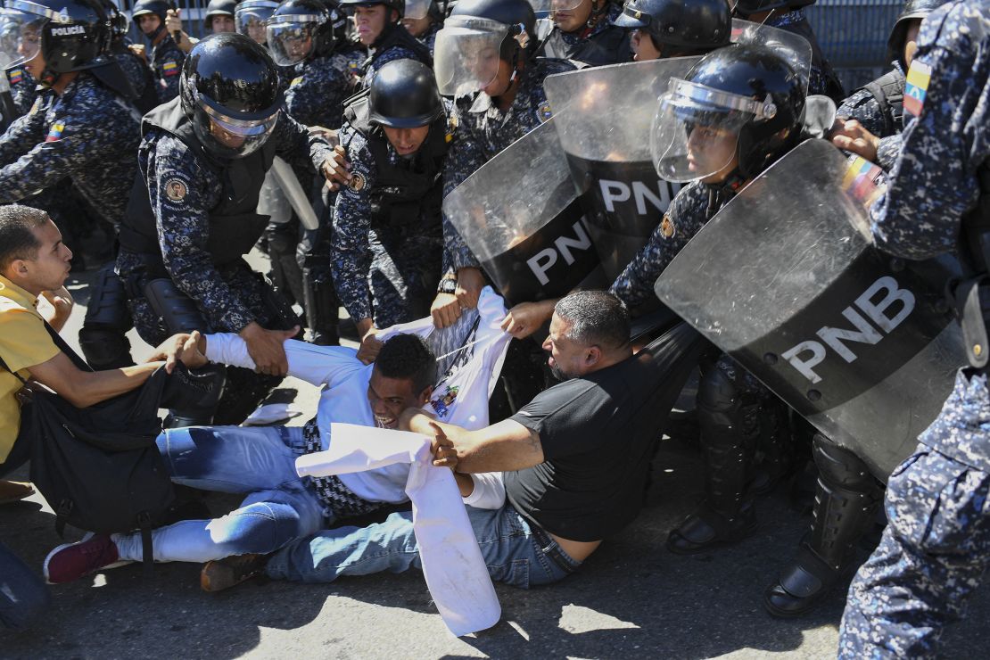 TOPSHOT - Supporters of Venezuelan opposition leader and self-proclaimed acting president Juan Guaido, scuffle with members of the Bolivarian National Police as they attempted to block a main avenue during a protest against the government of President Nicolas Maduro in Caracas, Venezuela, on November 18, 2019. (Photo by Yuri CORTEZ / AFP) (Photo by YURI CORTEZ/AFP via Getty Images)