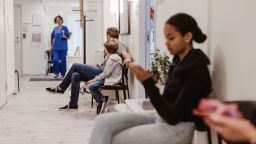 Los pacientes se sientan en la sala de espera de un hospital.