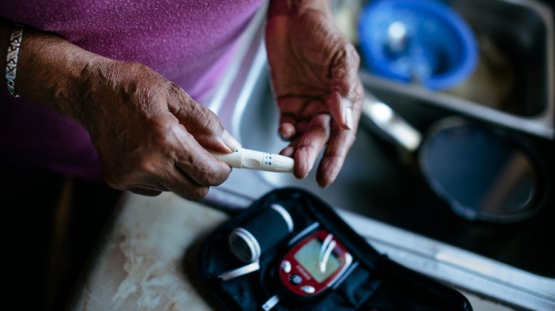 A woman checks her blood sugar levels with a diabetes home test kit.