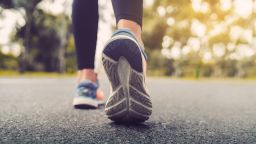Woman feet running on road closeup on shoe. Young fitness women runner legs ready for run on the road. Sports healthy lifestyle concept.