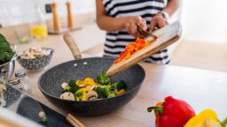 Close-up of young woman with tablet cooking in kitchen at home