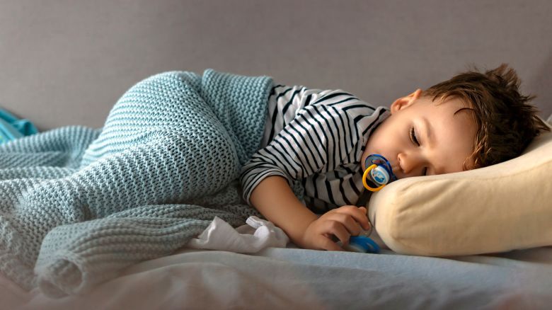 Adorable two years old boy sleeping on sofa during the day with copy space.