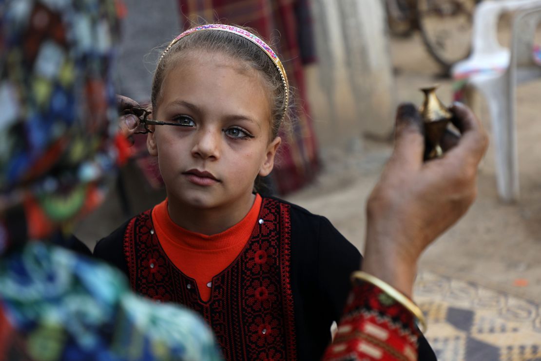 A Palestinian woman Hadeya Qudaih applying traditional kohl eyeliner to her granddaughter in Khan Younis in southern Gaza Strip in March 2020.