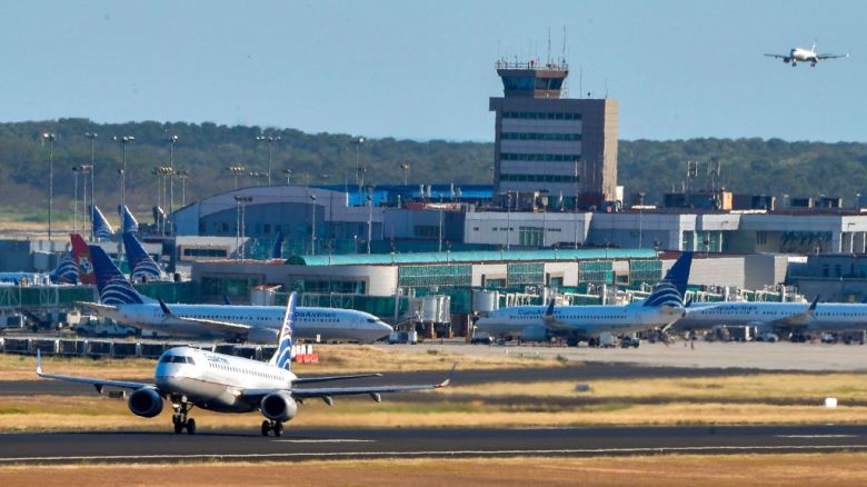 Un avión de la aerolínea Copa circula por la pista de aterrizaje mientras otros permanecen en la pista del Aeropuerto Internacional de Tocumen, el 22 de marzo de 2020.