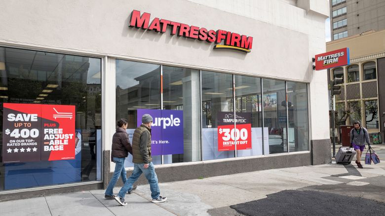 Pedestrians walk past a Mattress Firm Holdings Corp. store in San Francisco, California, U.S., on Tuesday, March 24, 2020.