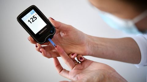 A woman with diabetes uses a glucometer to measure the glycemia in her blood in Paris on March 24, 2020, on the eighth day of a strict lockdown in  aimed at curbing the spread of COVID-19 caused by the novel coronavirus. (Photo by FRANCK FIFE / AFP) (Photo by FRANCK FIFE/AFP via Getty Images)