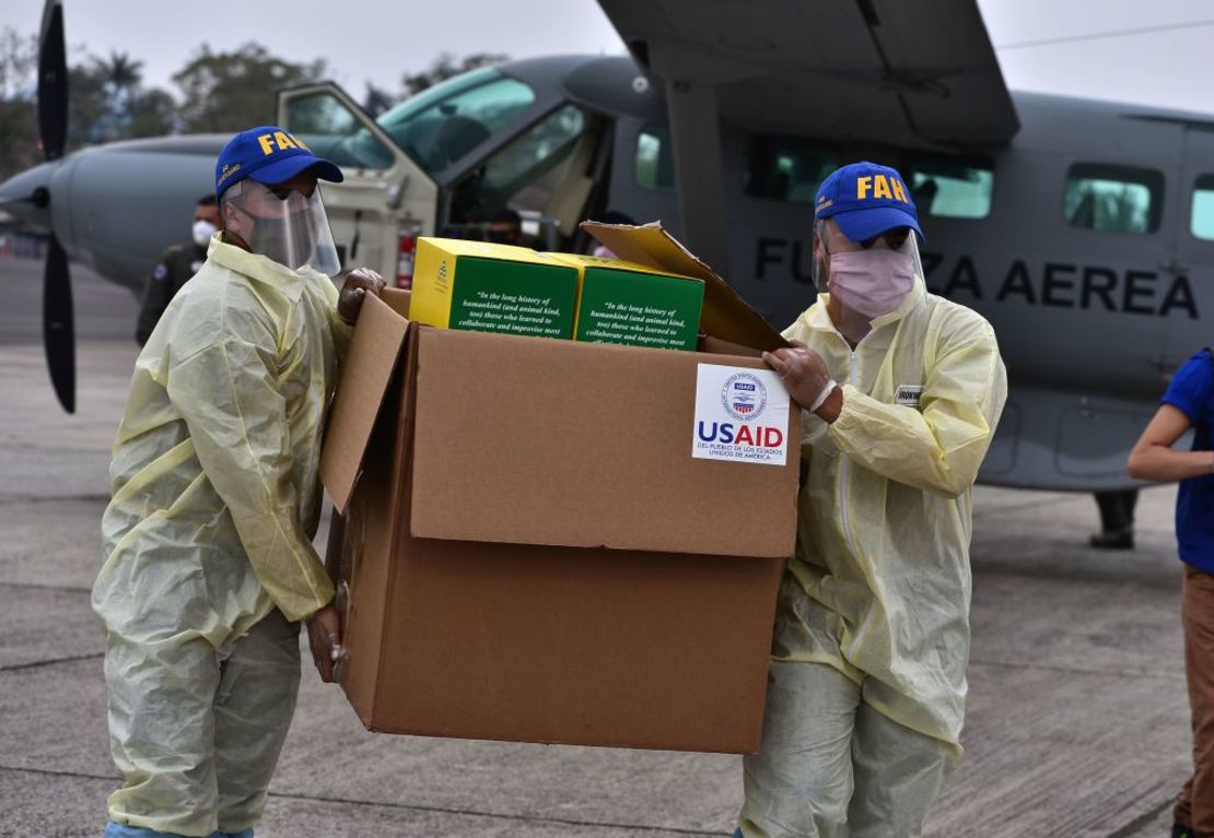 Miembros de las Fuerzas Armadas de Honduras llevan una caja que contiene algunos de los 8.000 kits de pruebas de diagnóstico donados por la USAID y la OIM para luchar contra la pandemia del coronavirus covid-19, en el aeropuerto de Tegucigalpa el 29 de abril de 2020