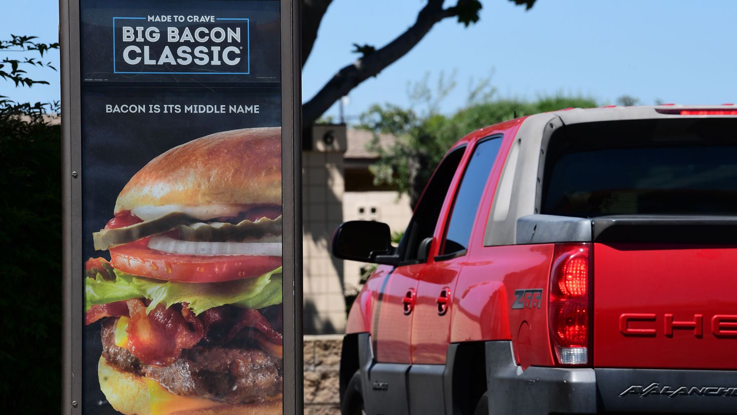 A driver in a vehicle places his order from a drive-thru lane at a Wendy's fast food restaurant in Alhambra, California on May 5, 2020.