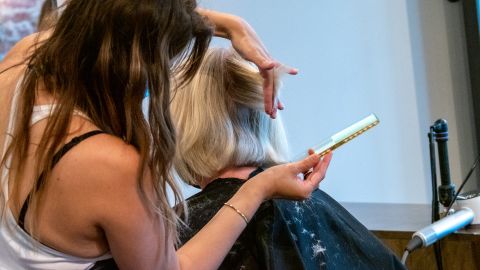 A cosmetologist styles a customer's hair at Parlour Salon in Ohio, United States in May 2020.