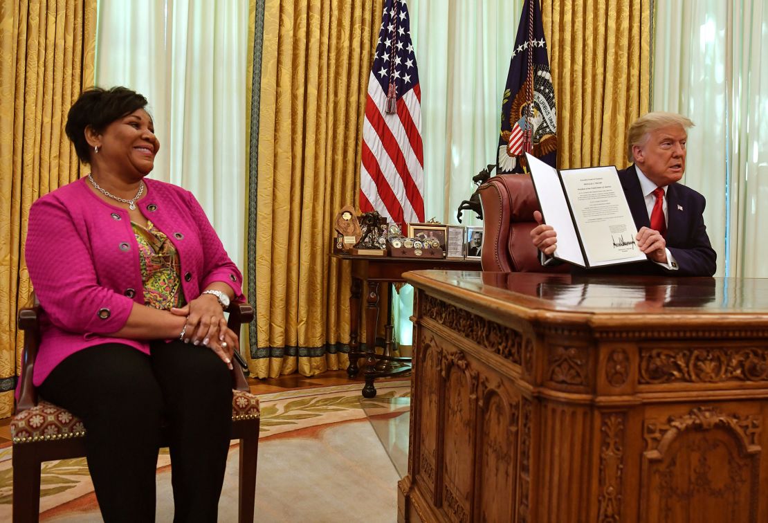 US President Donald Trump displays Alice Johnson's full pardon in the Oval Office of the White House in Washington, DC, on August 28, 2020.