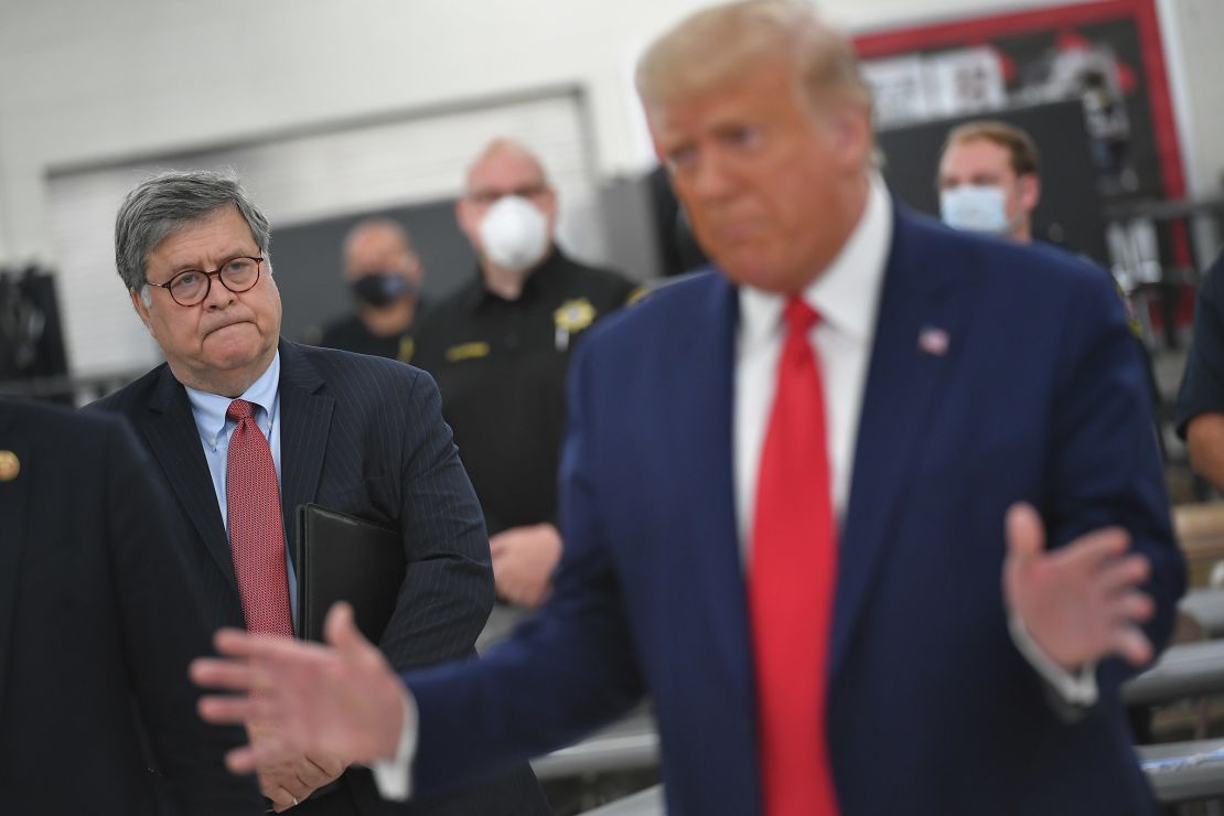 Attorney General William Barr listens to President Donald Trump at Mary D. Bradford High School in Kenosha, Wisconsin, on September 1, 2020.