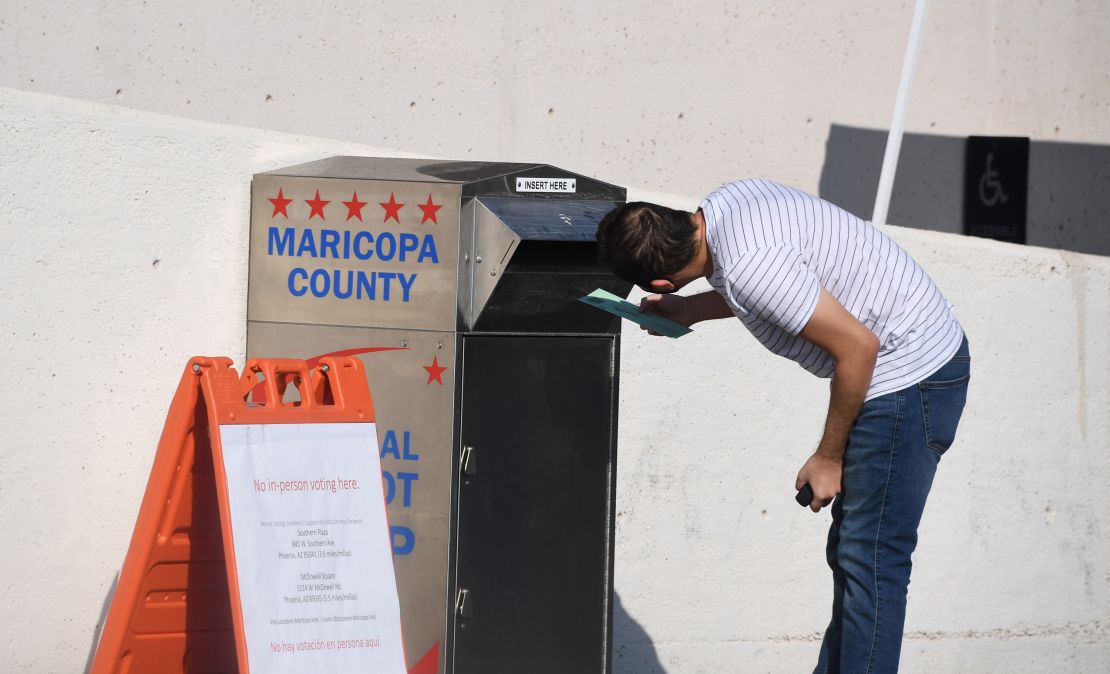 Voters deposit their mail-in ballots at a ballot collection box in Phoenix on October 18, 2020.