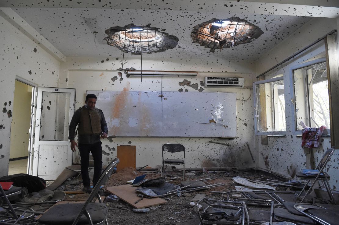 A journalist walks inside of a damaged class of the National Legal Training center, a day after gunmen stormed Kabul university in Kabul in November 2020.