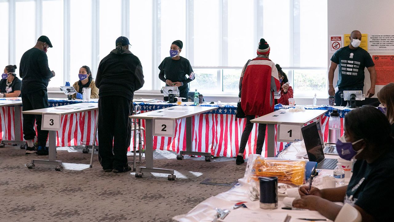 Voters check in with poll workers at a polling location for the 2020 presidential election in Atlanta on November 3, 2020.