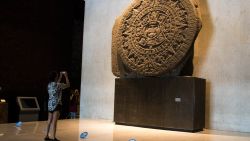 A woman takes a picture of an Aztec piece at the National Museum of Anthropology in Mexico City, on November 14, 2020, amid the COVID-19 coronavirus pandemic. (Photo by CLAUDIO CRUZ / AFP) (Photo by CLAUDIO CRUZ/AFP via Getty Images)