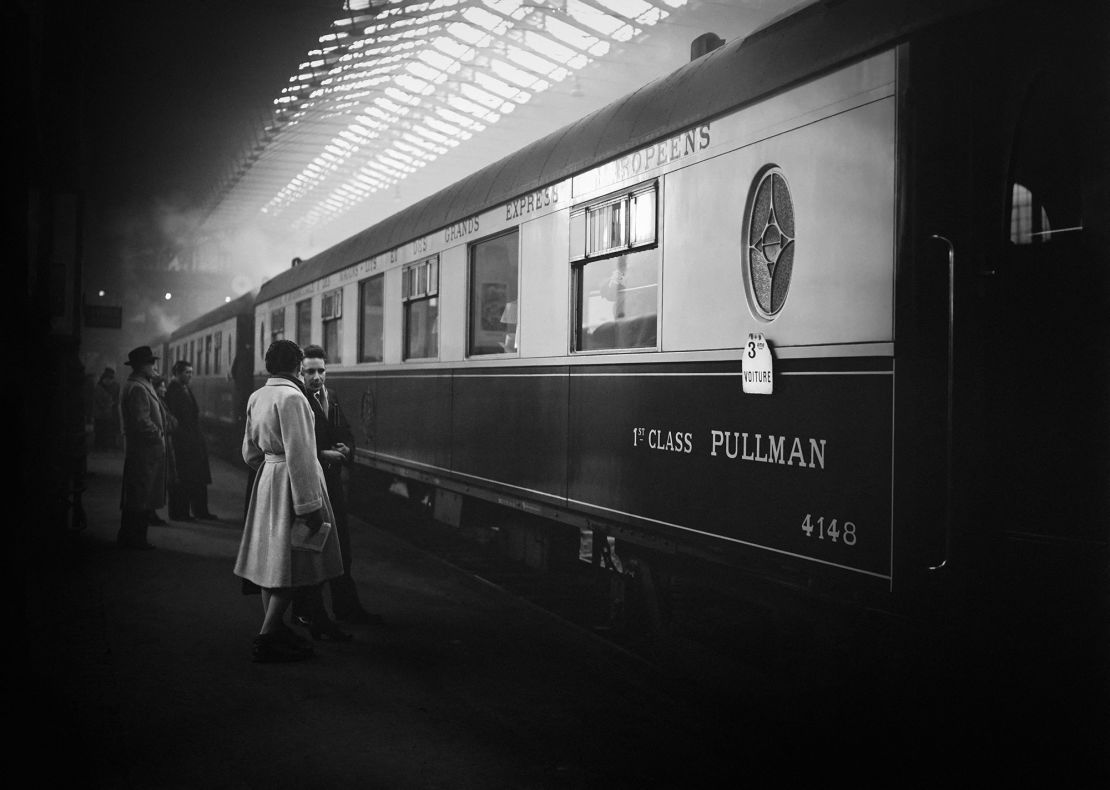 People wait on the platform in front of Le Train Bleu, a luxury sleeper train operated by Wagons Lits from 1886 to 2003