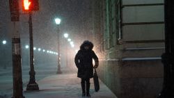 WILKES BARRE, PA - DECEMBER 16:  Car headlights illuminate a woman walking through city streets as snow accumulates on December 16, 2020 in Wilkes Barre, Pennsylvania.  Winter Storm Gail is expected to bring more than a foot of snow in parts of the Northeast.  (Photo by Mark Makela/Getty Images)