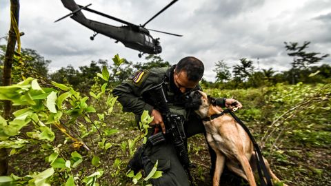 Un policía colombiano abraza a un perro durante un operativo para erradicar cultivos ilícitos en Tumaco, departamento de Nariño, Colombia, el 30 de diciembre de 2020.