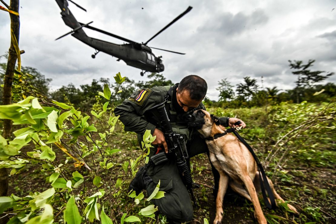 Un policía colombiano abraza a un perro durante un operativo para erradicar cultivos ilícitos en Tumaco, departamento de Nariño, Colombia, el 30 de diciembre de 2020.