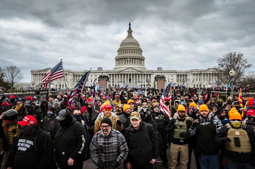 Pro-Trump protesters, including Proud Boys leader Joe Biggs, wearing a plaid shirt at bottom center of frame, gather in front of the US Capitol on January 6, 2021.