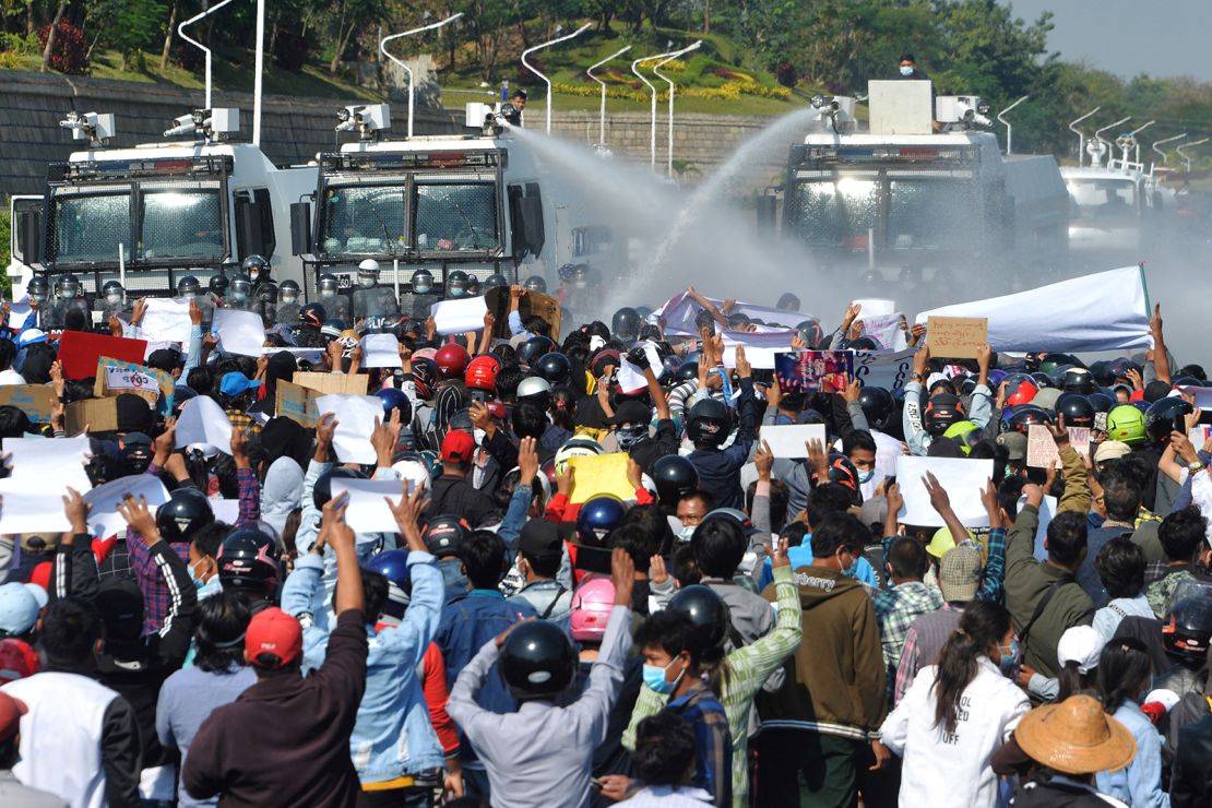 Myanmar police fire water cannon at protesters as they continue to demonstrate against the February 1 military coup in the capital Naypyidaw on February 9, 2021.