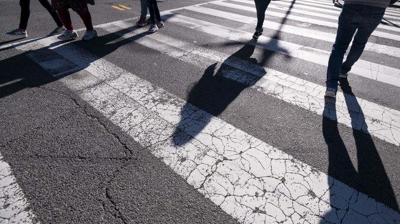 Pedestrians cross the street using a crosswalk in downtown Washington on Monday, March 29, 2021.