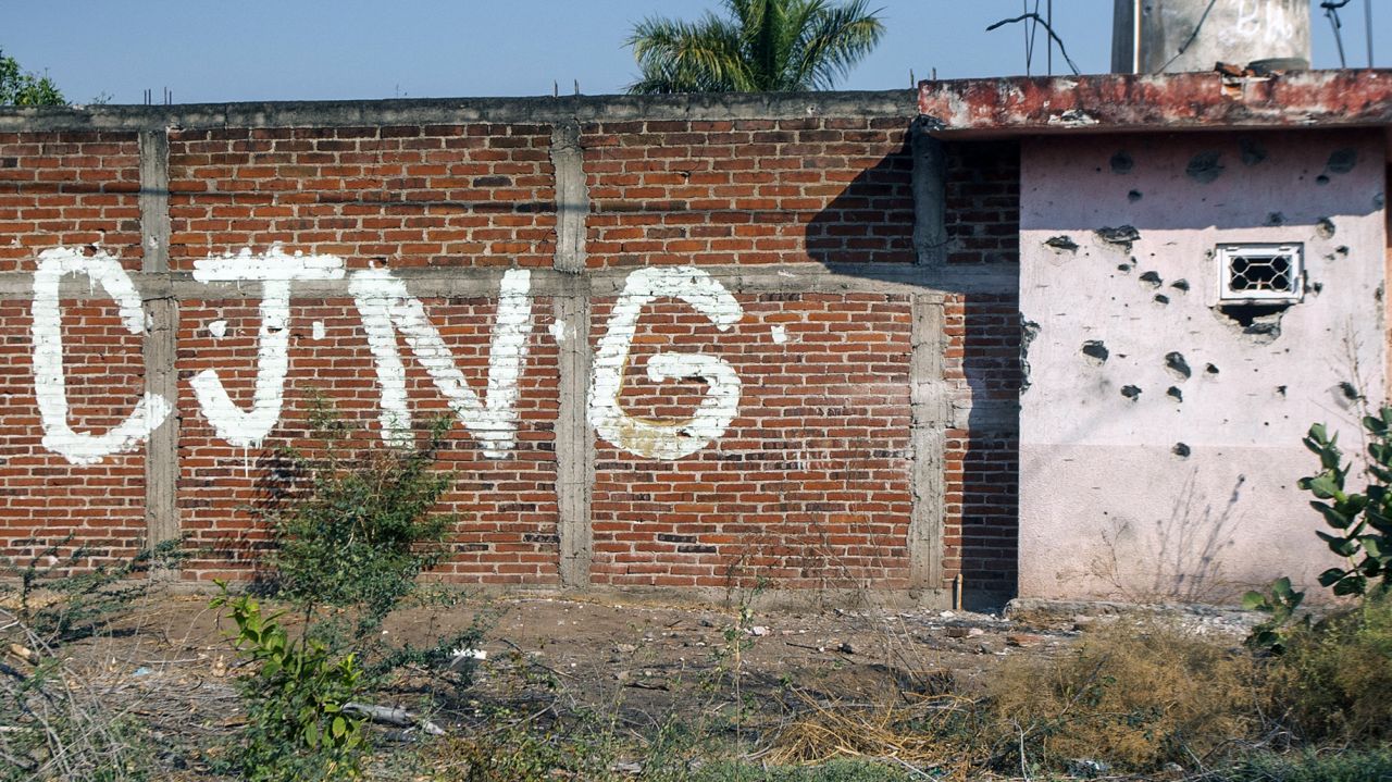 View of a bullet-riddled wall bearing the initials of the criminal group Cartel Jalisco Nueva Generacion (CJNG) at the entrance of the community of Aguililla, state of Michoacan, Mexico, on April 23, 2021. - The municipality of Aguililla is being threatened due to the confrontation of organized crime groups called the Jalisco Nueva Generacion Cartel (CJNG) and the Michoacan Family (now called Viagras). (Photo by ENRIQUE CASTRO / AFP) (Photo by ENRIQUE CASTRO/AFP via Getty Images)