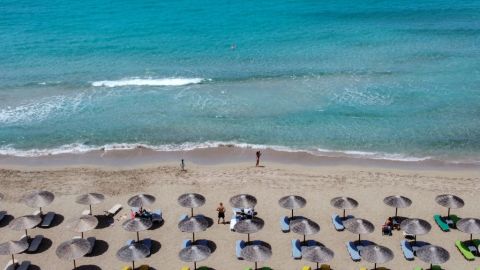 Paraguas frente al mar en la playa de Falaserna (Phalasarna), en la costa occidental de la isla de Creta, el 15 de mayo de 2021. - Los turistas disfrutaron del calor, el sol y las aguas cristalinas de Creta.durante las esperadas vacaciones, en el arranque de la temporada turística griega tras la pandemia del año pasado
