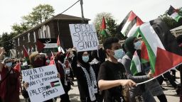 Pro-Palestinian supporters hold signs while marching during a protest against the Israel-Hamas crisis in Dearborn, Michigan, U.S., on Tuesday, May 18, 2021. PresidentÂ Joe BidenÂ told Prime MinisterÂ Benjamin Netanyahu hed support a cease-fire between Israel and Hamas after days of calling for calm but not publicly seeking an end to the conflict, a shift in the U.S. approach to the crisis following days of rising criticism. Photographer: Matthew Hatcher/Bloomberg via Getty Images