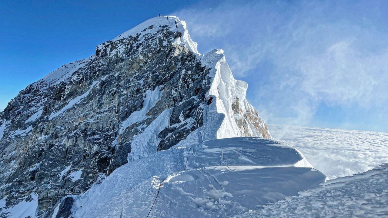 This photograph taken on May 31, 2021 shows mountaineers climbing the Hillary Step during their ascend of the South face to summit Mount Everest (8,848.86-metre), in Nepal. (Photo by Lakpa SHERPA / AFP) (Photo by LAKPA SHERPA/AFP via Getty Images)