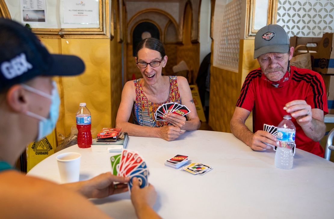 Morgan Coder, left, plays Uno with Kathleen Stoughton, 64, center, and Kathleen's husband Kim, 61, at a cooling center in Portland, Oregon in 2021.