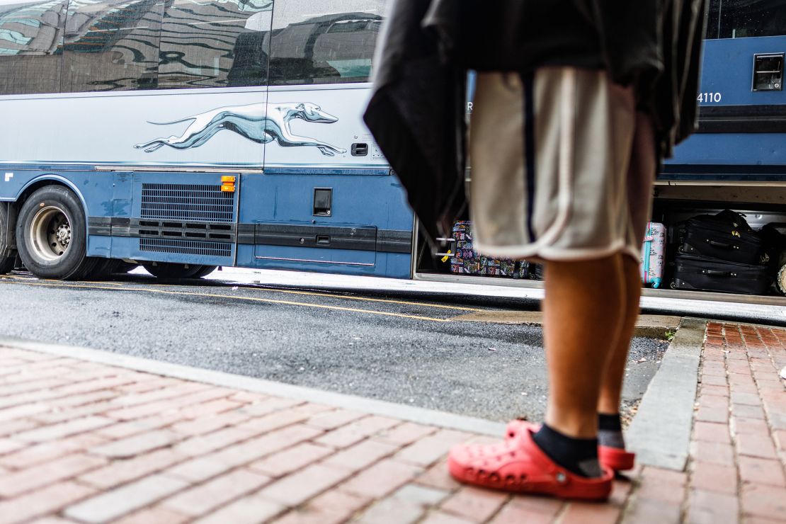 A passenger at a Greyhound bus terminal waits for a mechanic to fix a bus's flat tire in Harrisburg, PA, in July 2021.