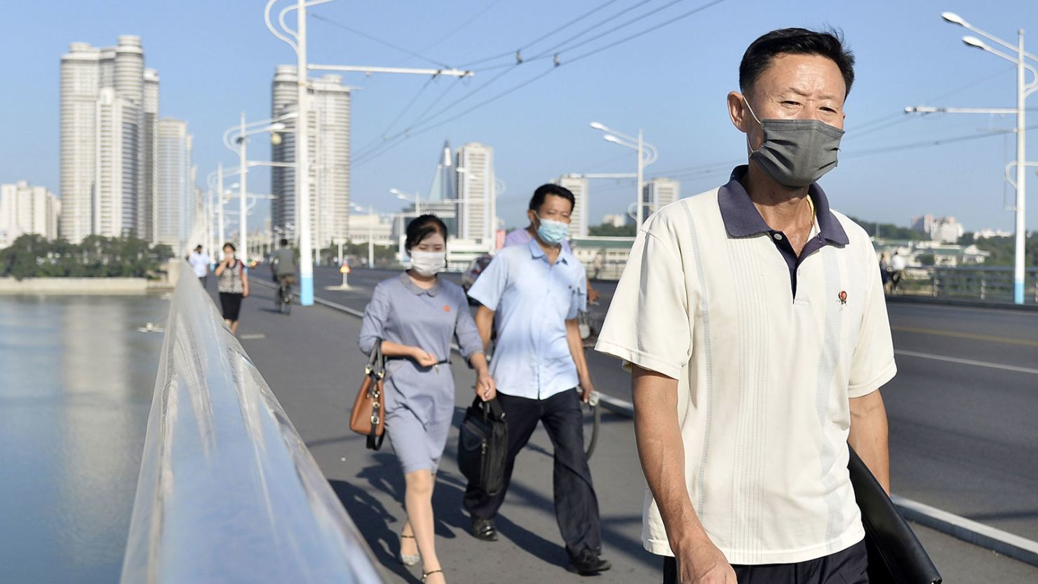 People wearing face masks for protection against Covid-19 walk in Pyongyang on Aug. 19, 2021.