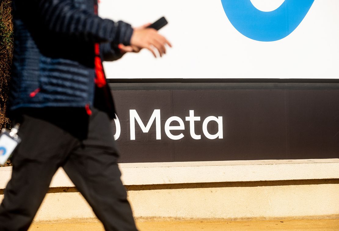 A person walks past a newly unveiled logo for "Meta", the new name for Facebook's parent company, outside Facebook headquarters in Menlo Park on October 28, 2021.
