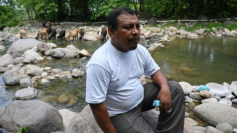 Honduran environmentalist Juan Lopez sits on a rock as he watches the Guapinol river on the outskirts of Tocoa, Colon department, Honduras, on September 28, 2021. - Juan Lopez leaves home every day fearing he will not return. He says he has lived in anxiety since fighting against mining in a mountainous area of crystalline rivers and thick forests in northeastern Honduras, one of the most dangerous countries in the world for environmentalists. (Photo by Orlando SIERRA / AFP) (Photo by ORLANDO SIERRA/AFP via Getty Images)