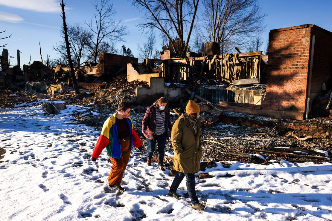 People walk through a neighborhood decimated by the Marshall Fire on January 2, 2022, in Louisville, Colorado.