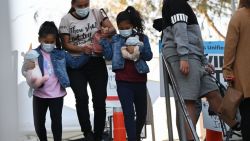 Two girls carry stuffed animal toys wearing face masks as they leave a Covid-19 screening at a testing and vaccination site at public school in Los Angeles, California, January 5, 2022. - The United States reported more than one million new Covid-19 cases on January 4 after the long New Year's weekend, according to data from Johns Hopkins University, as the Omicron variant spread at a blistering pace. (Photo by Robyn Beck / AFP) (Photo by ROBYN BECK/AFP via Getty Images)