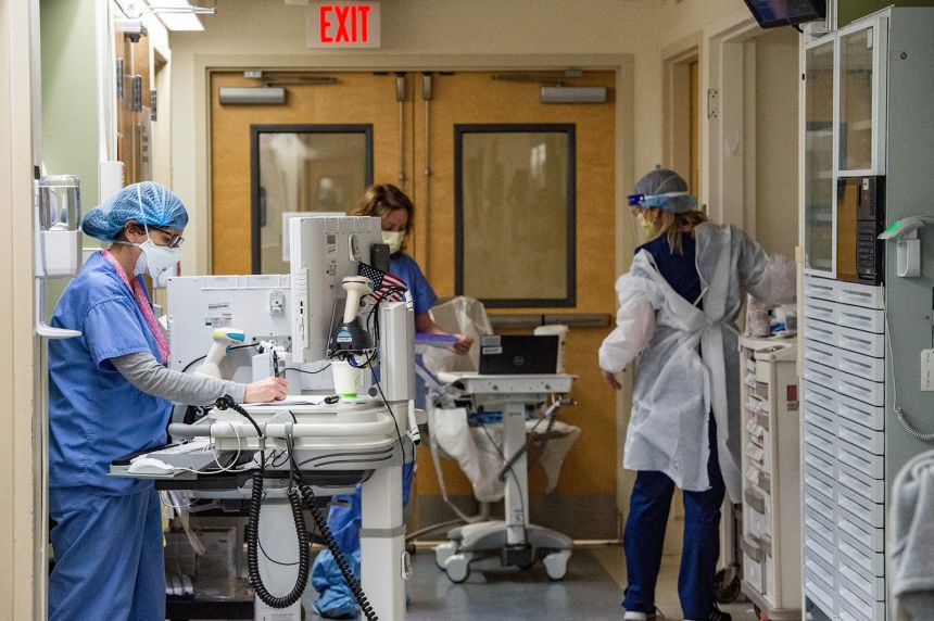 Medical workers treat patients in the Covid-19 ward at the US Department of Veterans Affairs Boston Healthcare system campus and medical center in West Roxbury, Massachusetts on January 11, 2022.
