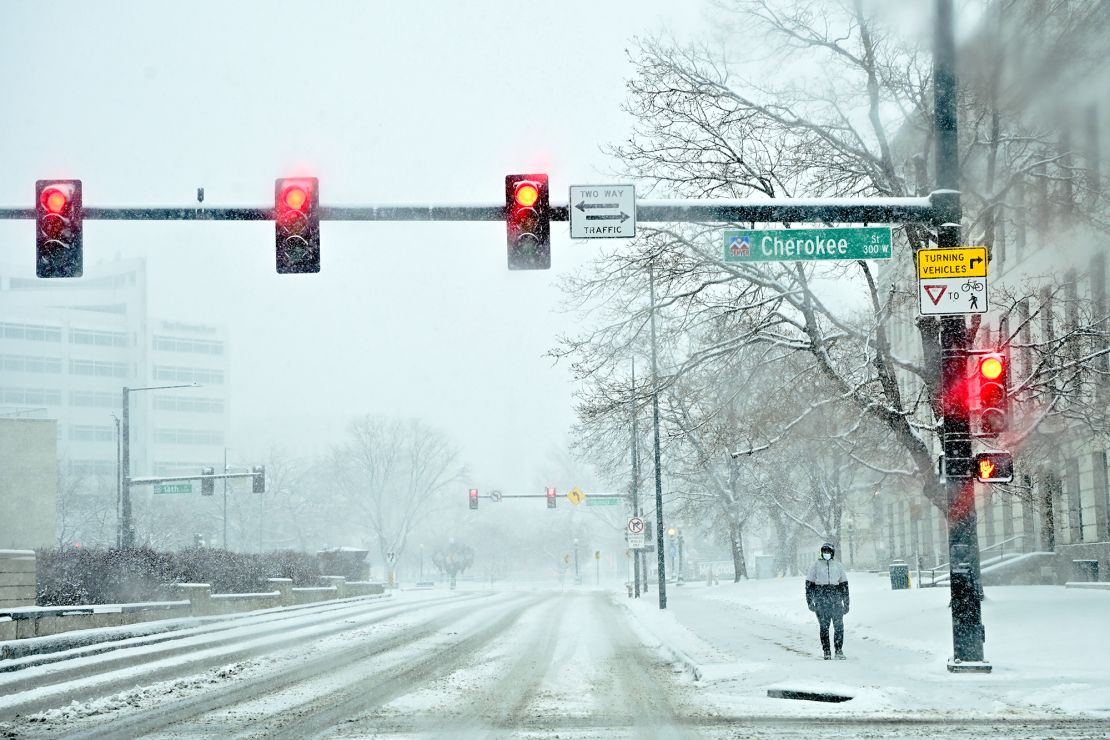 A pedestrian stops at a corner in Denver in 2022. Denver and other cities are considering banning right-on-red.